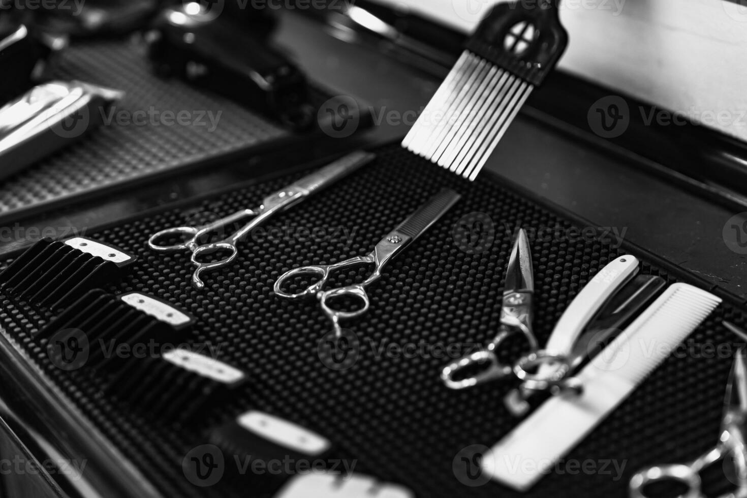 Sharp scissors and tools set on black textured surface in barbershop photo