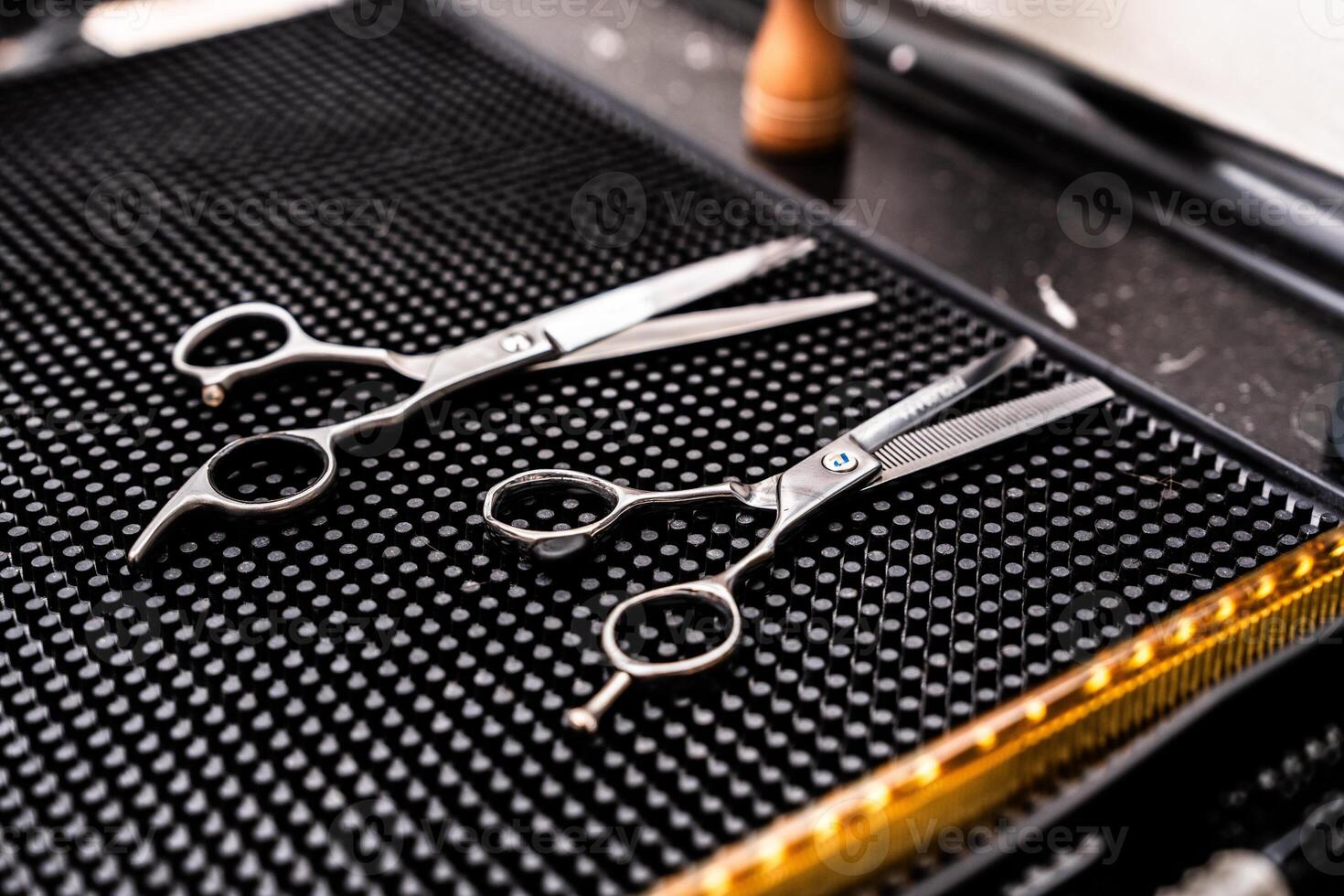 High-quality hairdressing scissors placed on a textured dark surface photo