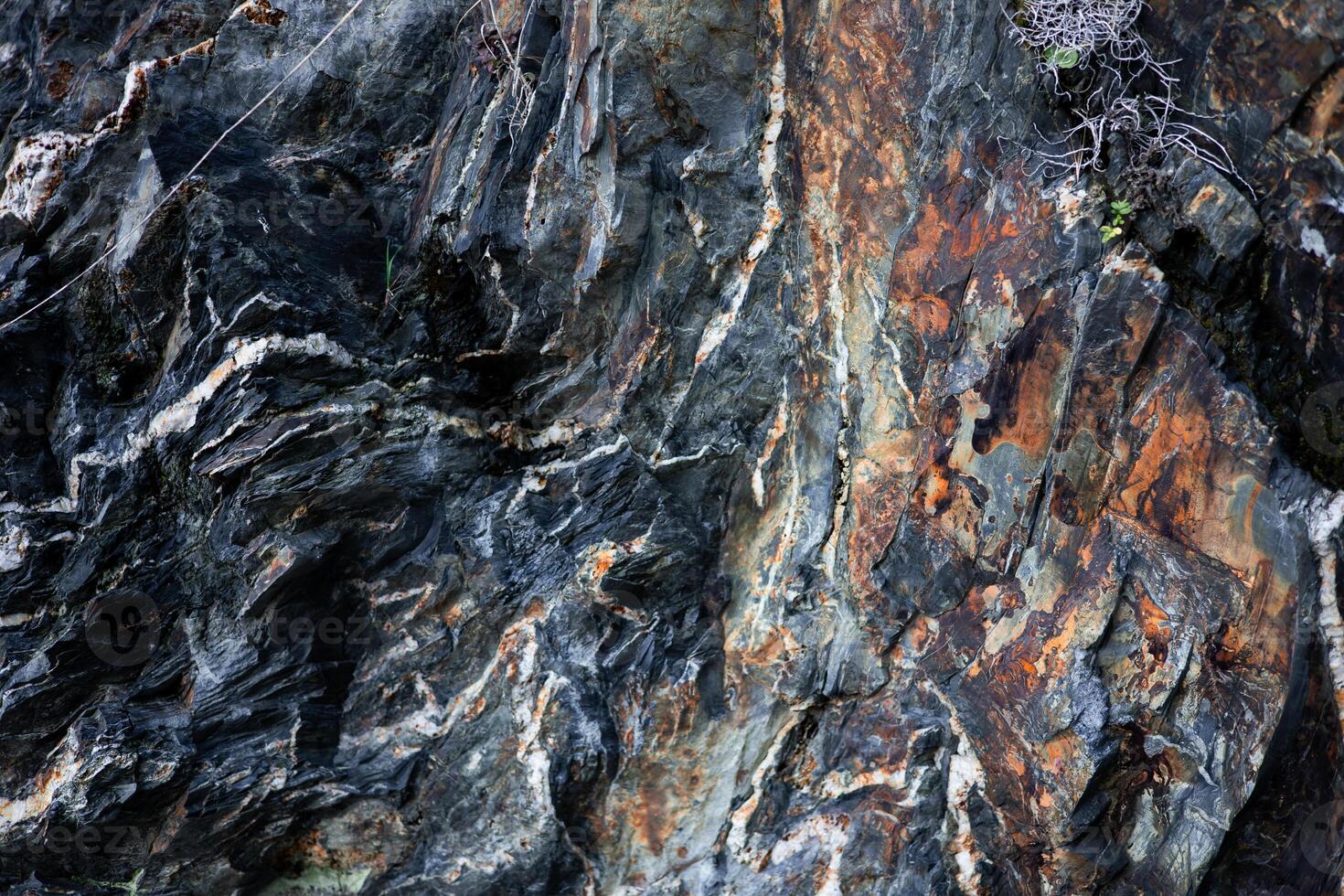 Close up of textured multicolored rock formation with striations photo