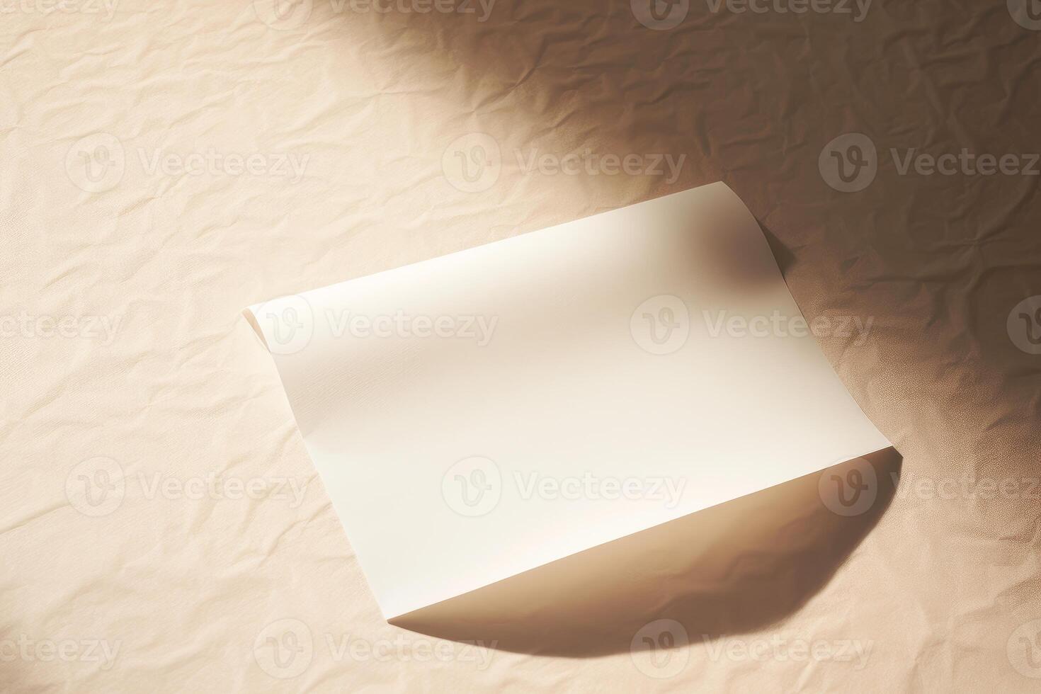 Blank paper sheet casting shadow on wrinkled beige fabric under natural light photo