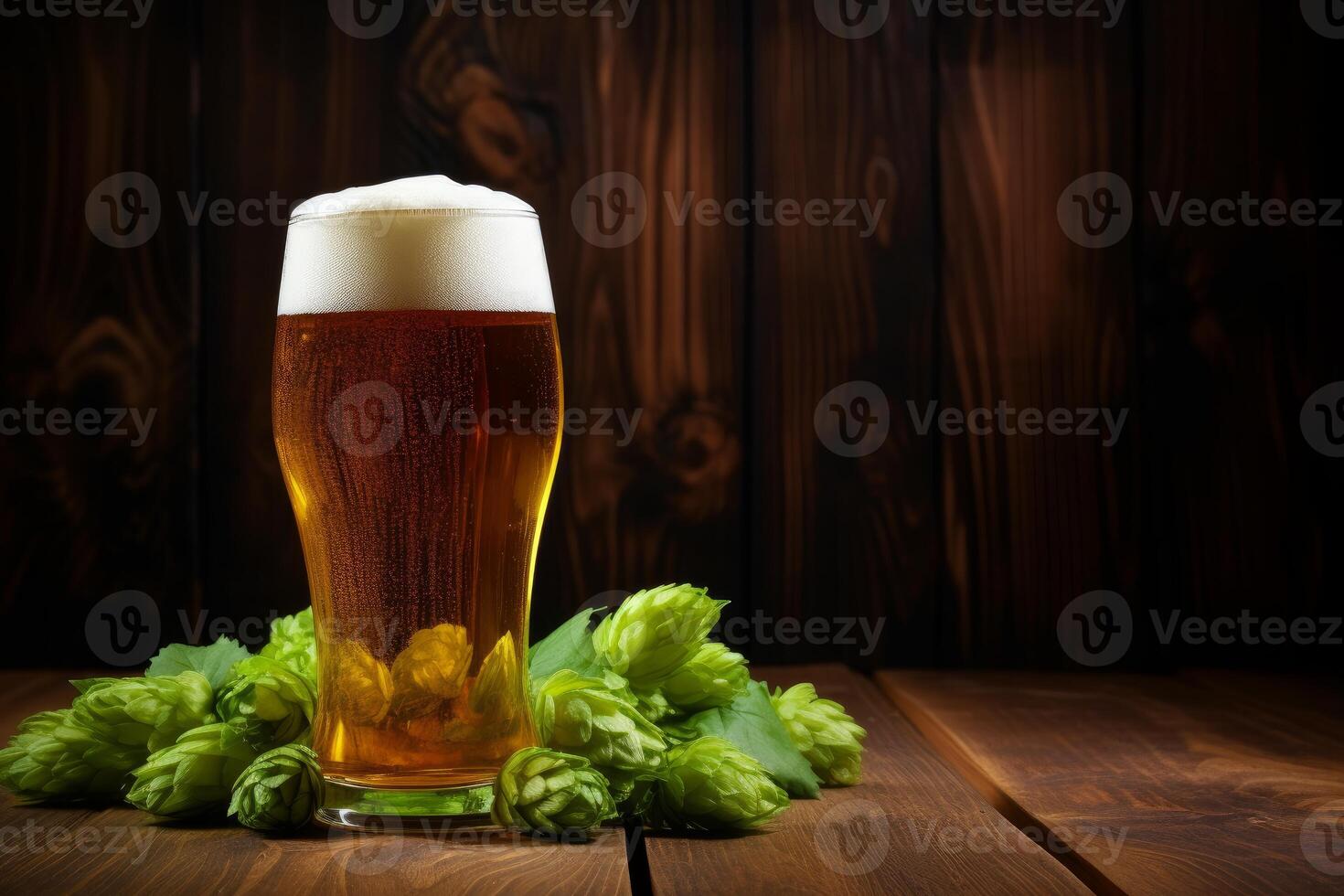 Glass of beer with hops on wooden table and dark background photo