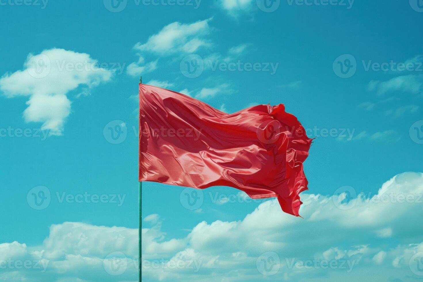 Red flag waving in the wind on cloudy sky photo