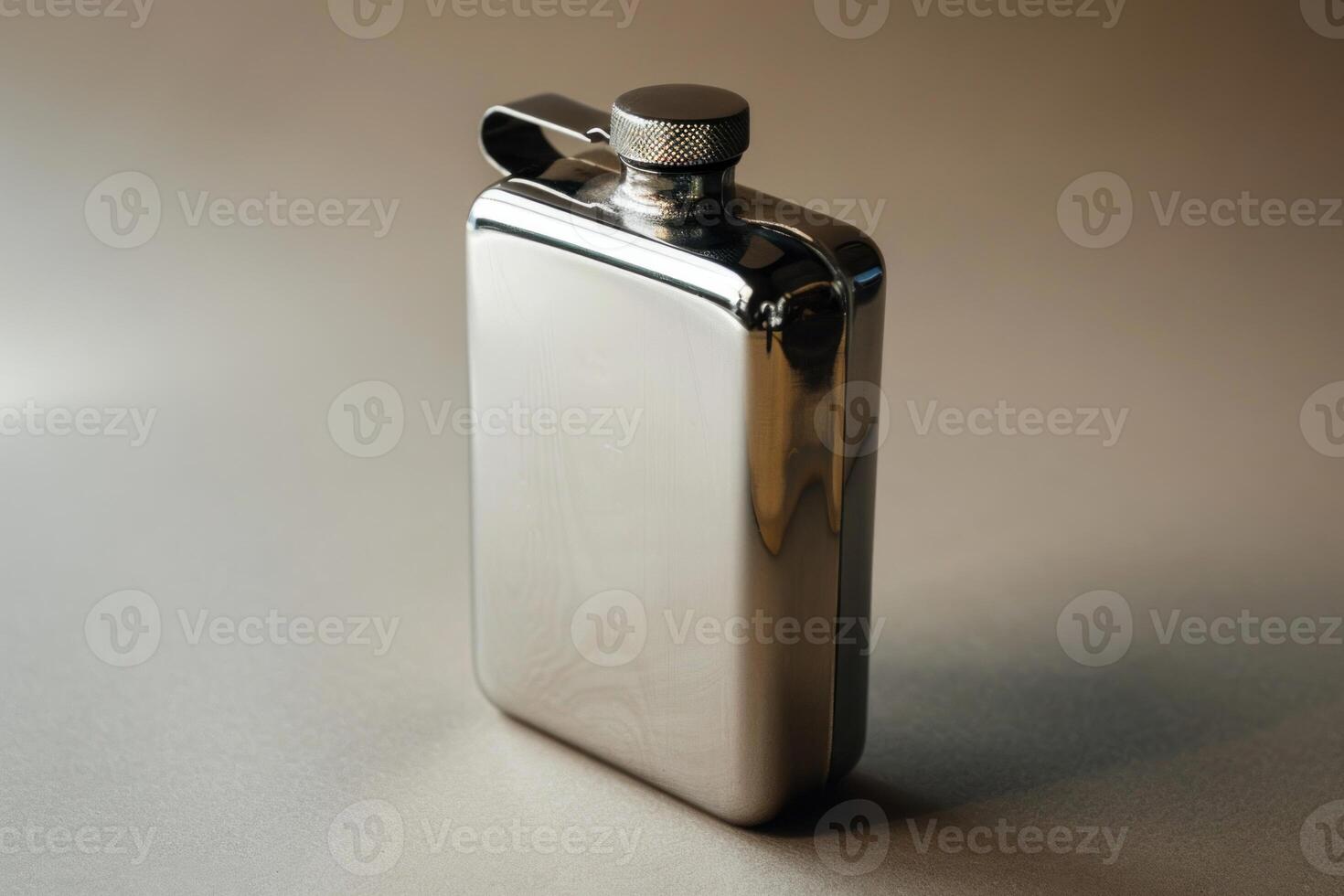 Closed metal hip flask standing on a reflective surface photo