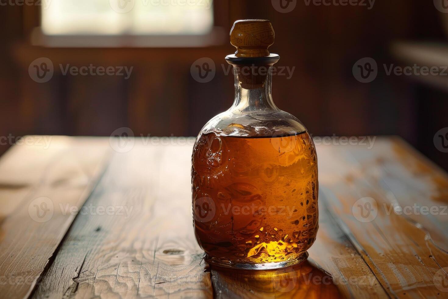 Crystal bottle of liquor sitting on rustic wooden table photo