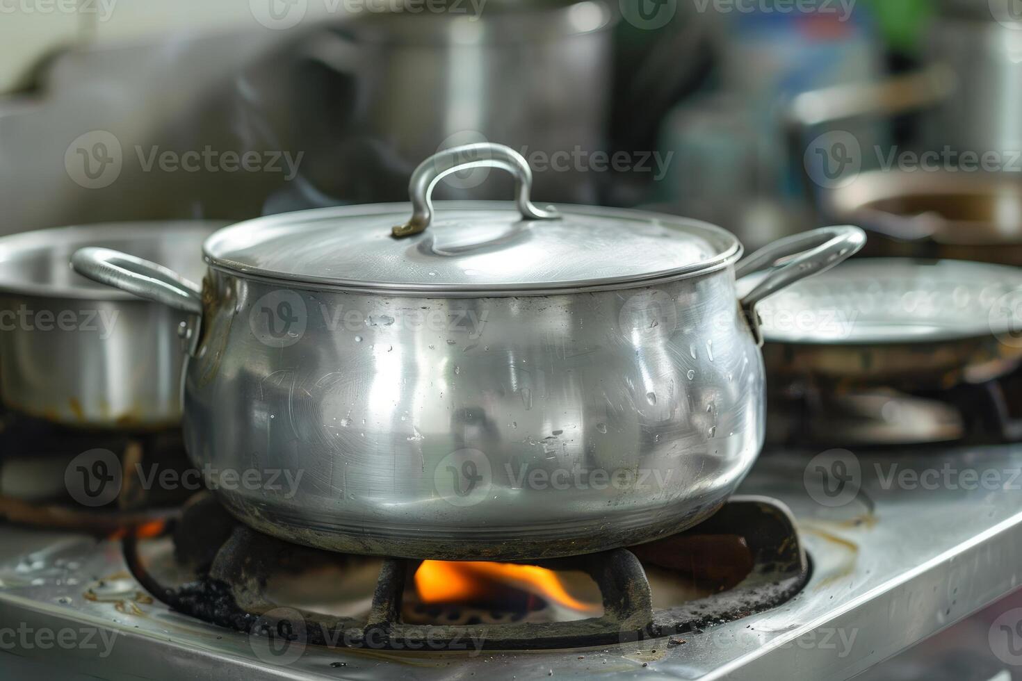 Large pot simmering on a gas stove in a restaurant kitchen photo