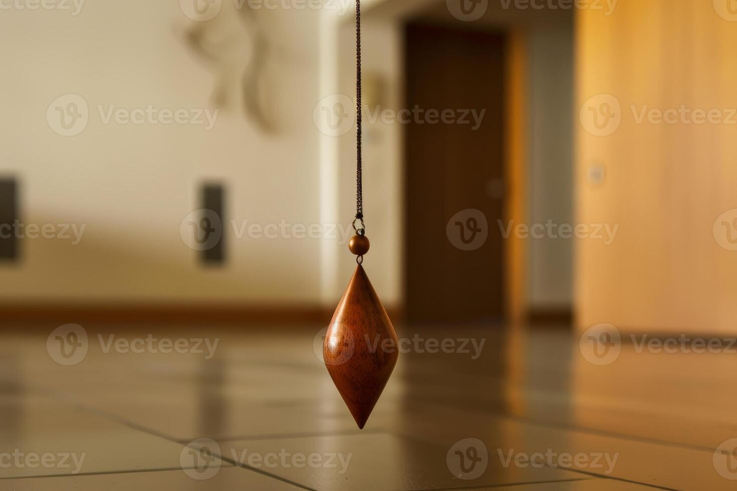 Wooden pendulum hanging from ceiling swinging gently photo