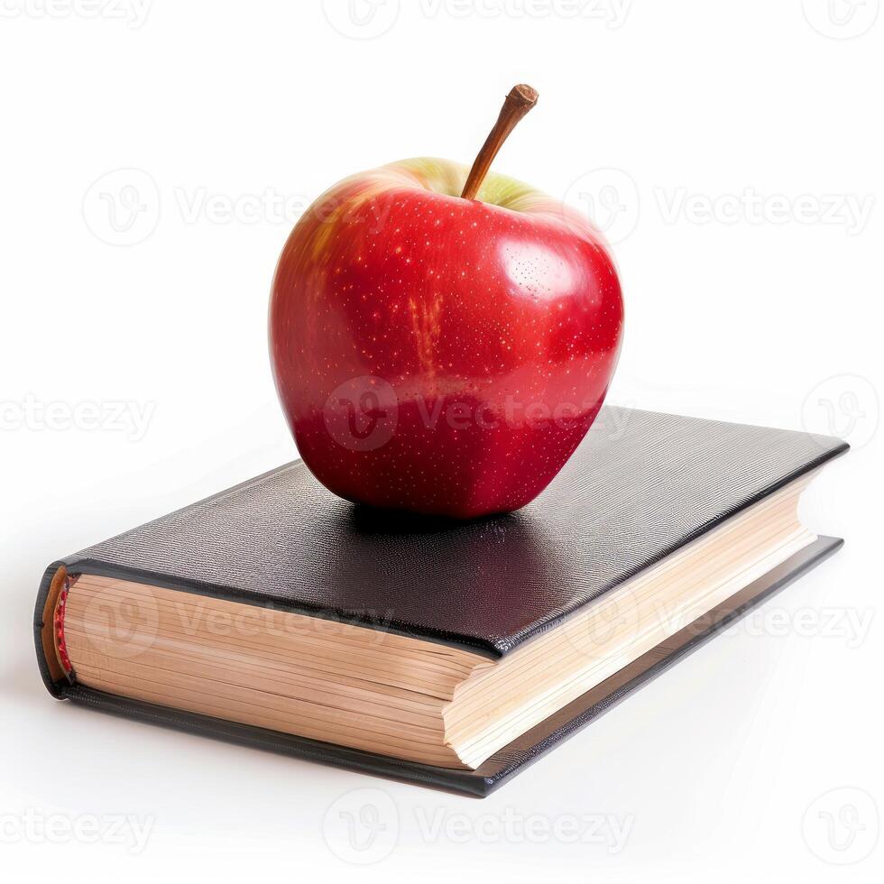 Red apple resting on top of a closed black book symbolizing education photo