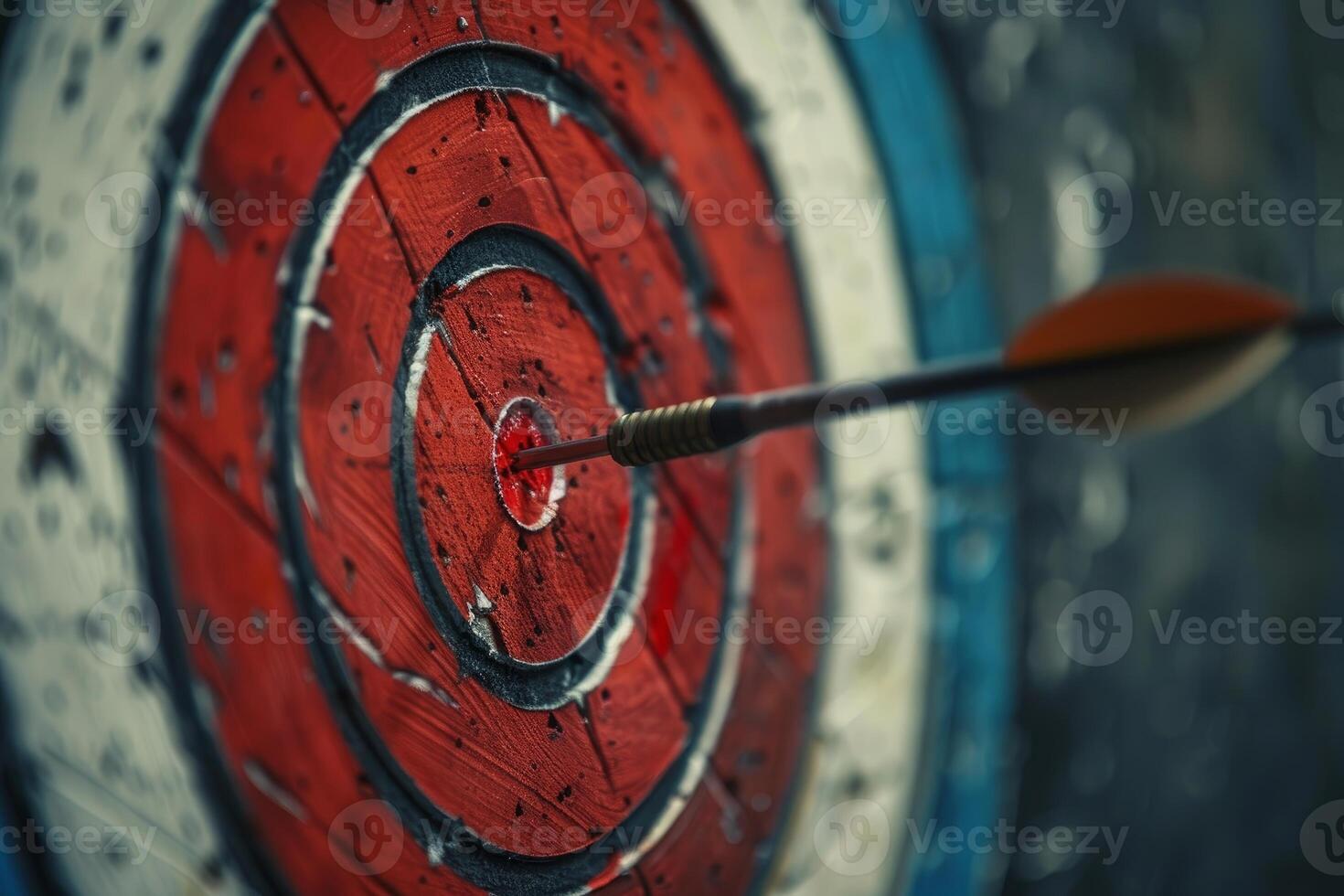Arrow hitting the center of an archery target on a wooden background photo