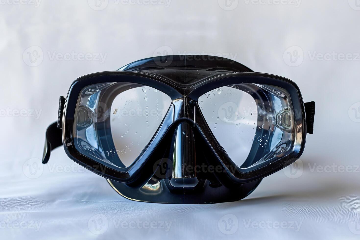 Black diving mask with water drops is lying on white background photo