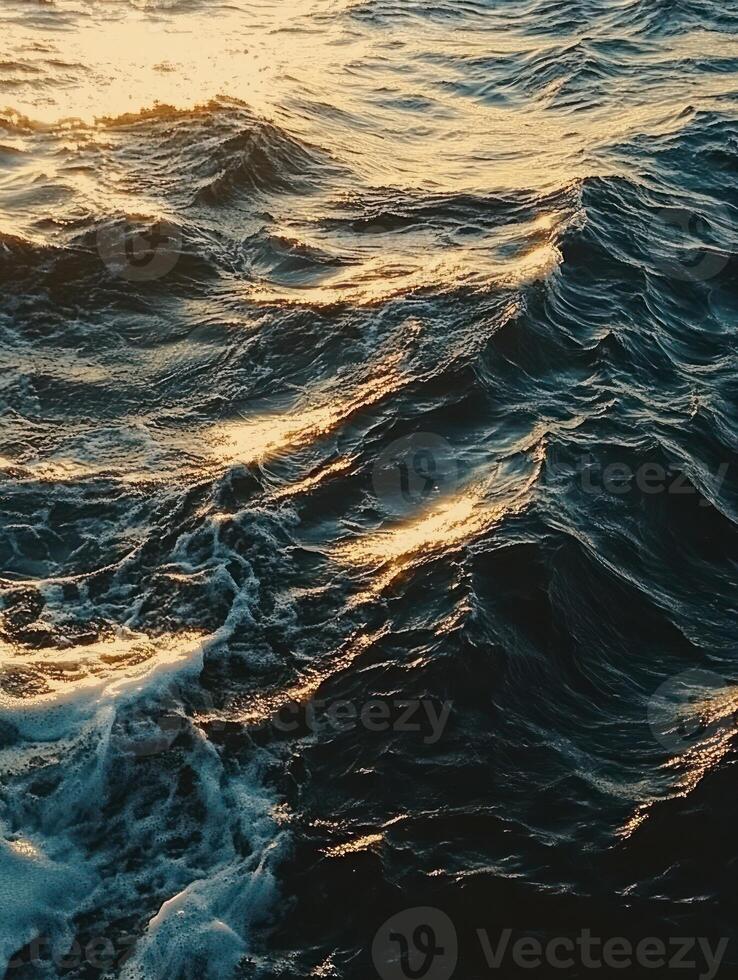 Dramatic rippling ocean waves at sunset reflecting golden light photo