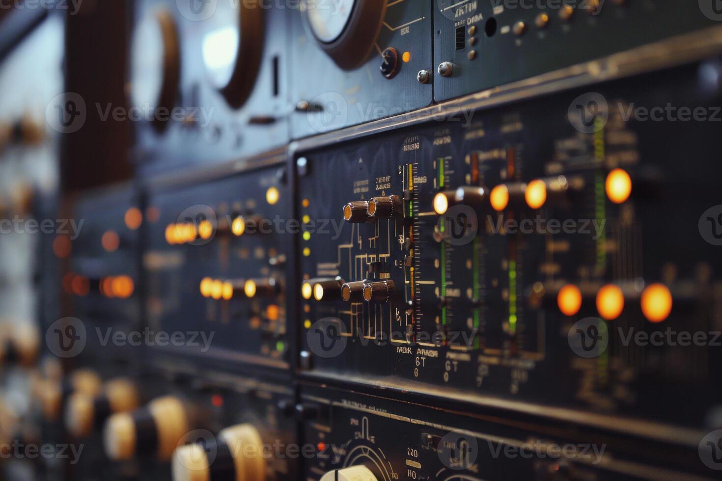 Vintage audio mixing console is showing its illuminated buttons in a dark studio photo