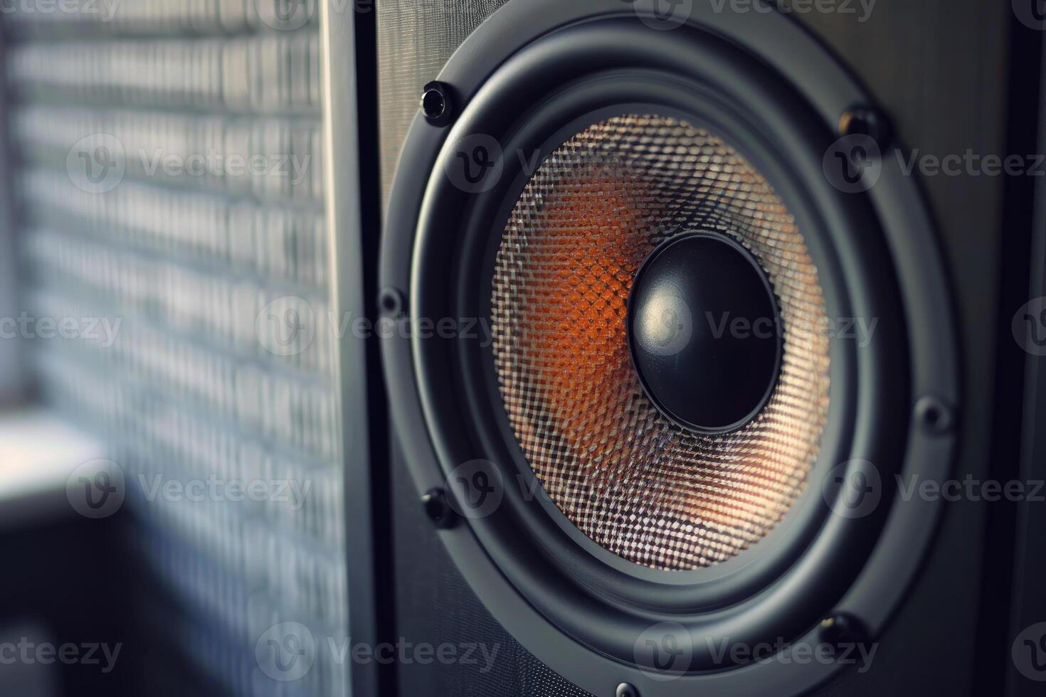 Powerful audio speaker vibrating with illuminated orange membrane is playing music photo