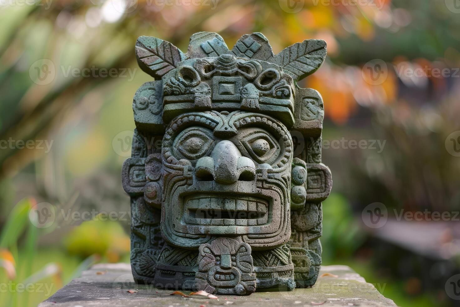 Weathered mayan statue is standing outdoors in a blurred garden photo