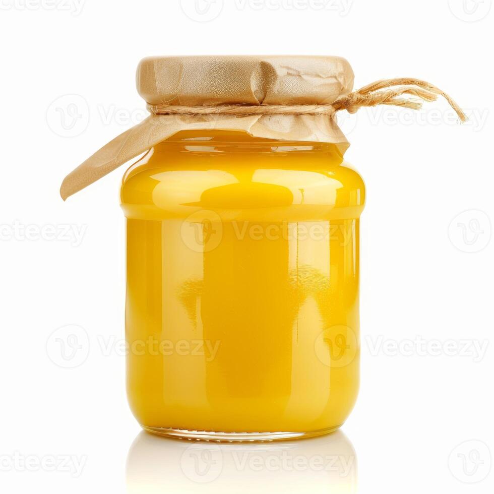 Glass jar of mango or peach puree covered with brown paper and tied with string on white background photo