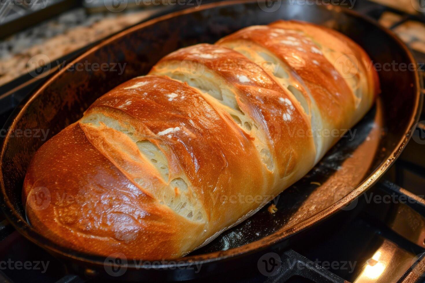 Homemade crusty bread baking in a cast iron skillet on gas stove photo