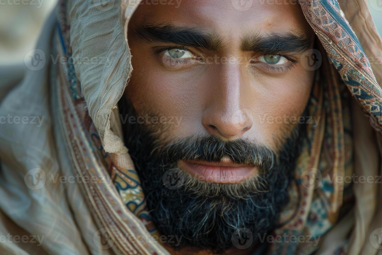 Portrait of bedouin man wearing traditional headdress showing intense gaze photo