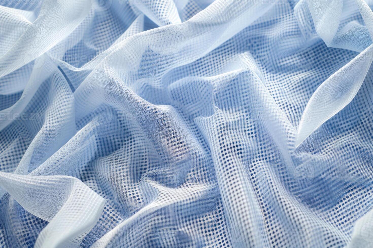 Light blue fabric with grid pattern forming soft folds photo