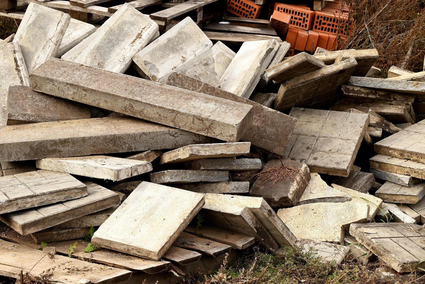 Construction waste On a beautiful sunny morning A pile of construction waste. Building rubble and stones. Abandoned garbage, junk, garbage piled up near the building. Street scene. Recycling industry. photo