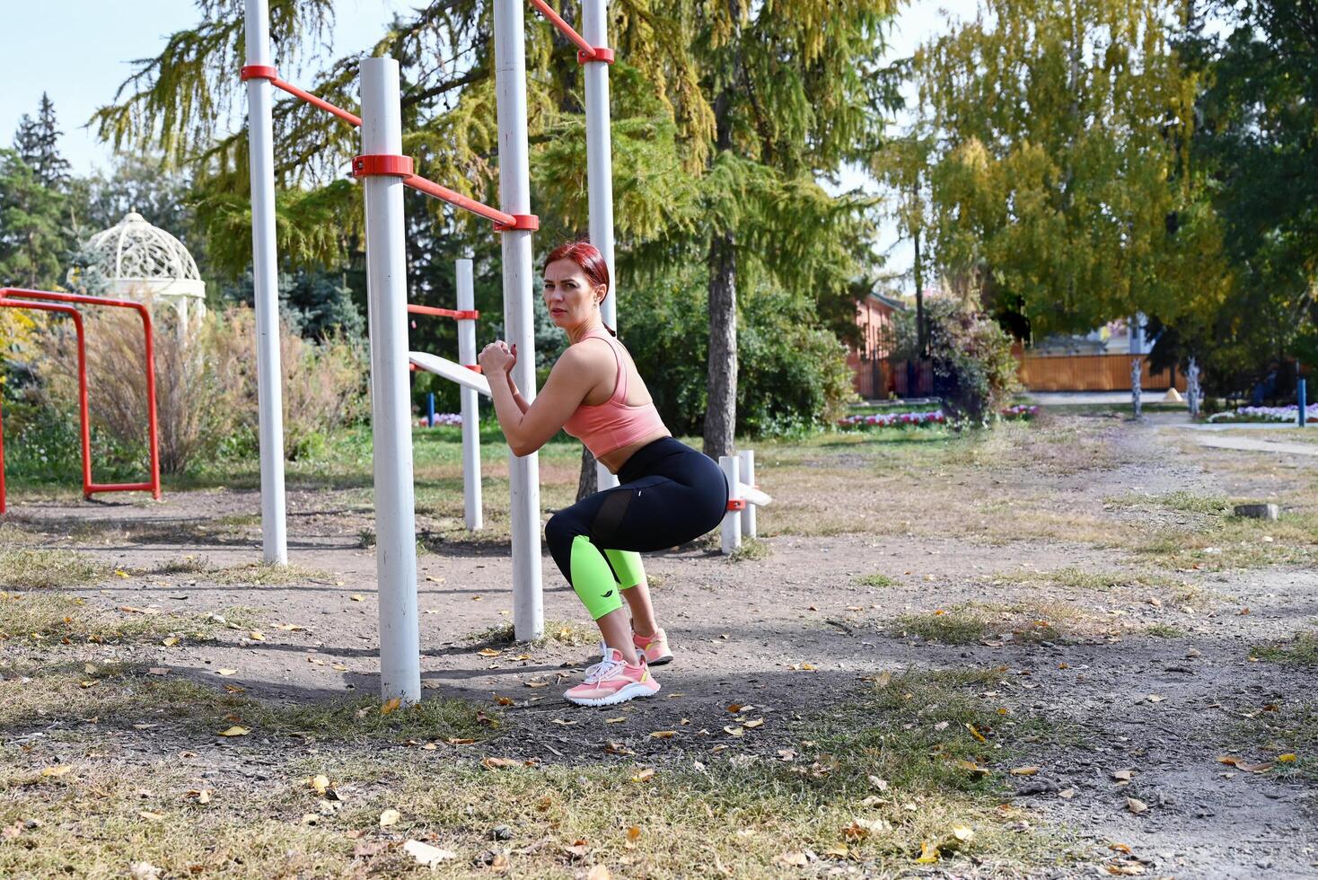 Outdoor fitness in the city. Healthy lifestyle. Coach exercises on the street. A confident woman does a workout. photo