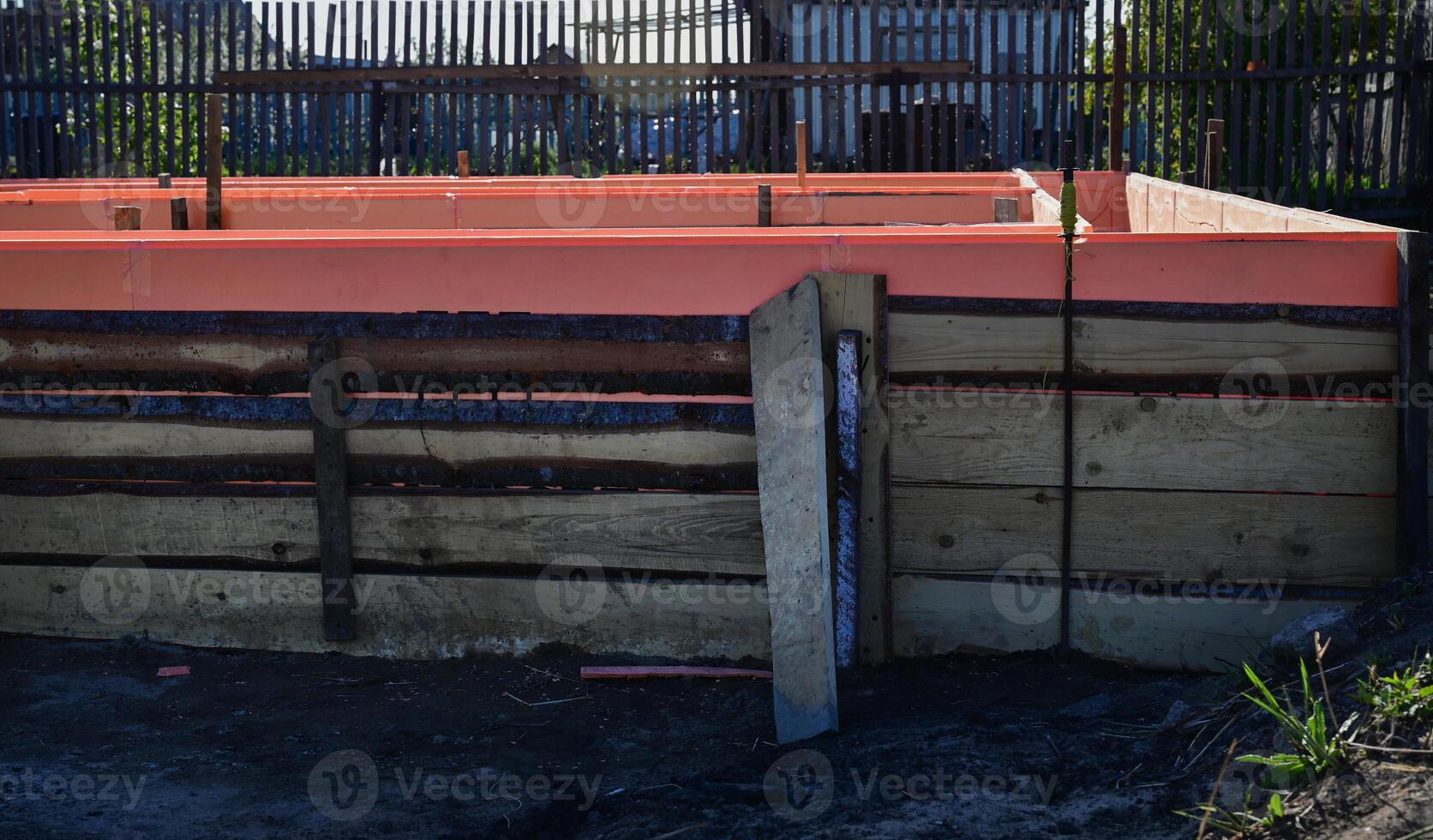 Wooden formwork on a sunny day with metal reinforcement prepared for pouring concrete. Installation using wire. Building a new house. photo