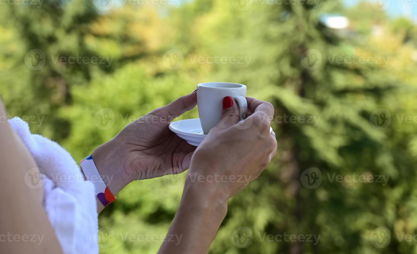 View of the reverse side of a beautiful luxury relaxing woman enjoying On a wonderful daya cup of coffee tea on a blue sky sea outdoor background photo