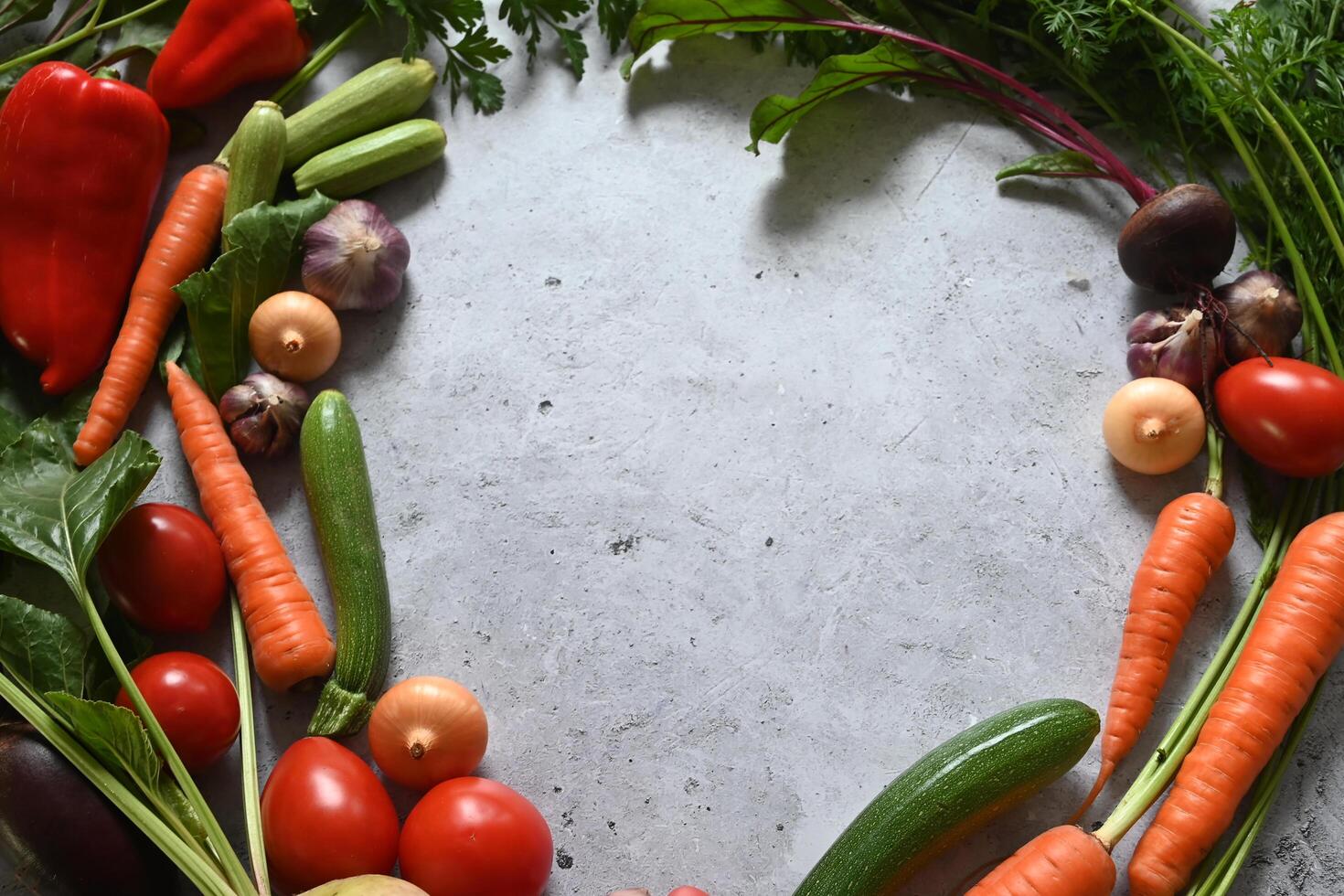 A circular arrangement of vegetables on a gray background. photo