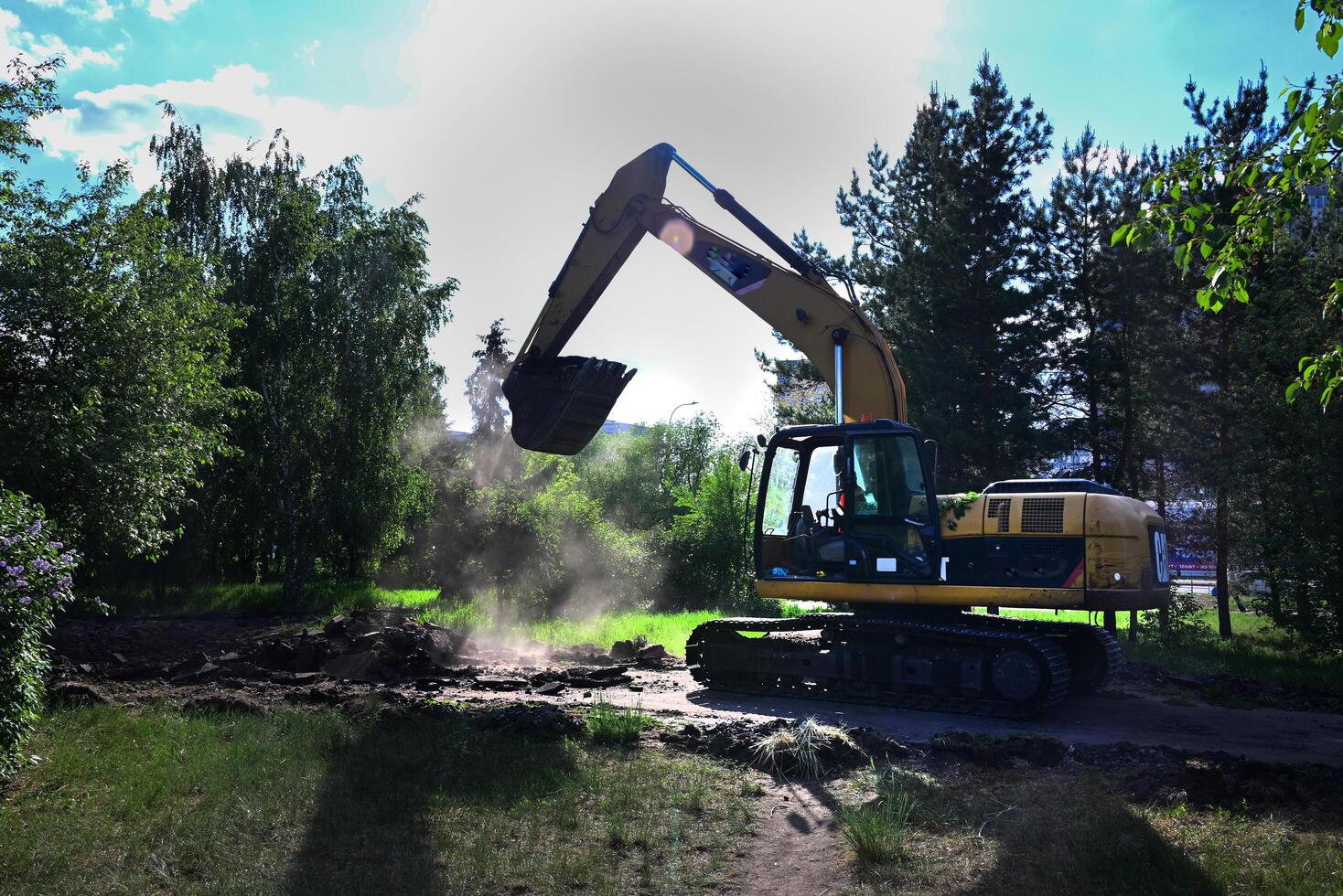 Excavator during earthmoving at open pit on blue sky background On a wonderful day with a positive attitude photo