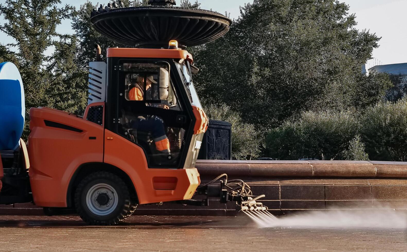 Truck watering a tree by spray water in the park at the morning On a wonderful day. photo