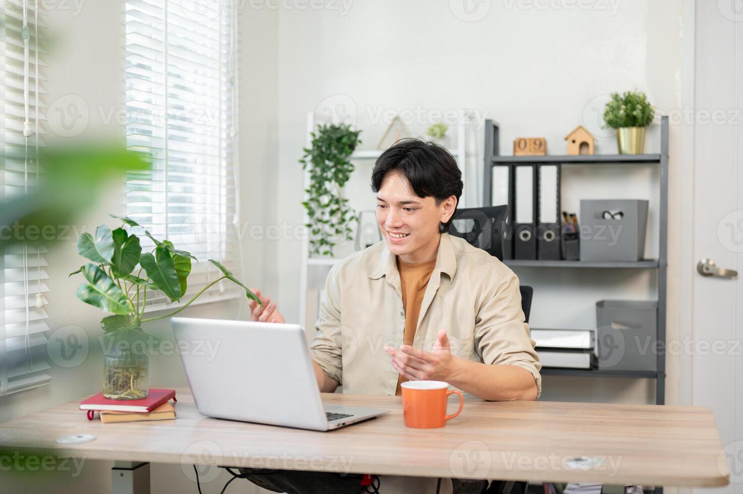 A confident Asian businessman having an online meeting with his client through his laptop. photo
