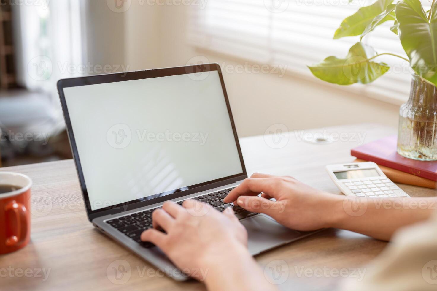 A close-up of a businessman working on his laptop at a desk in a minimalist office. photo
