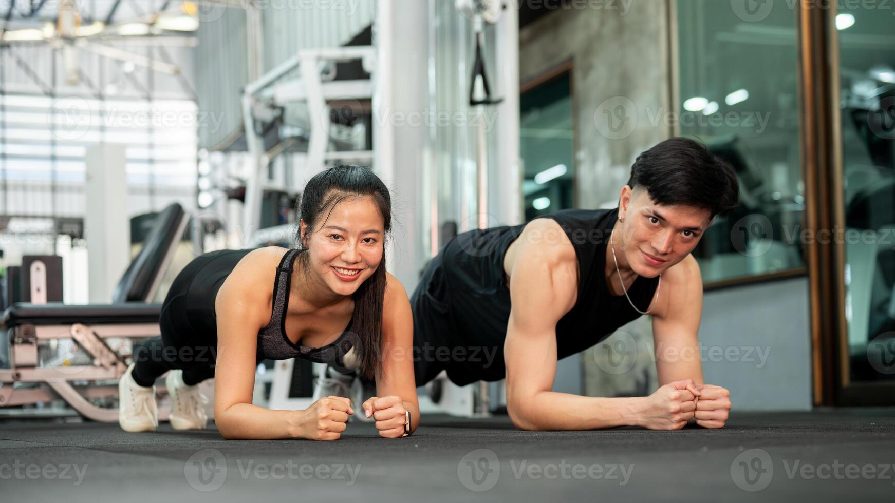 A supportive Asian couple is working out together in the gym. photo