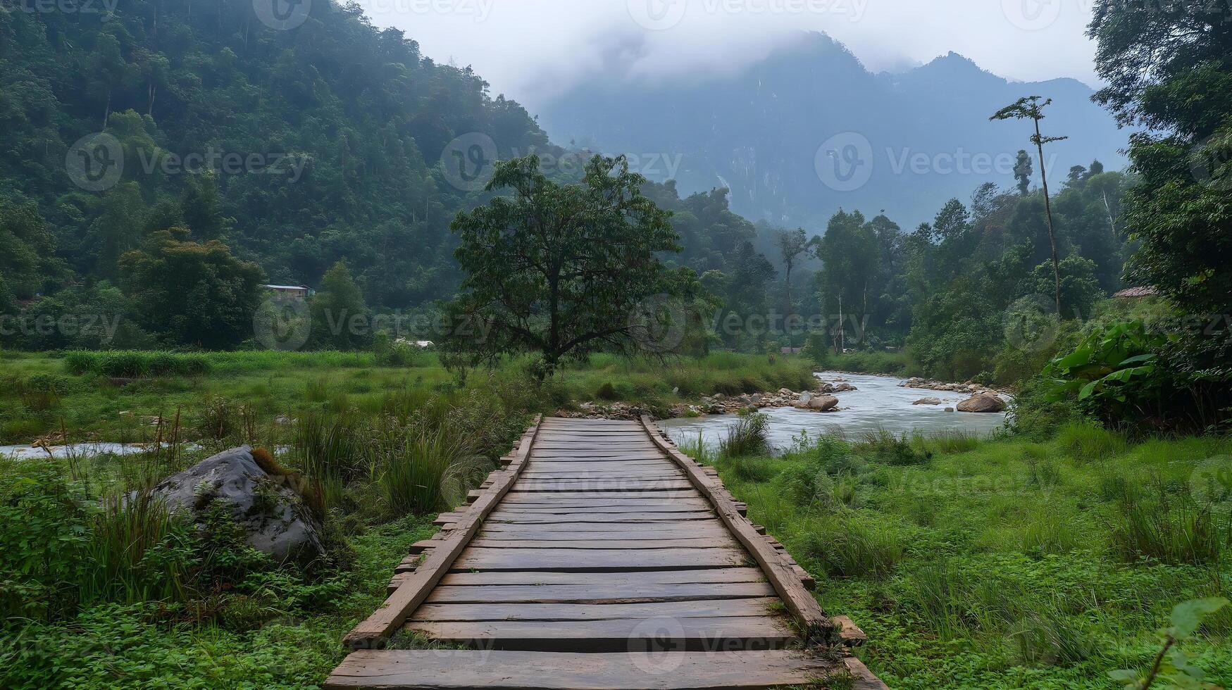 Rustic Wooden Bridge Over a Scenic River. A rustic wooden bridge stretches across a calm river, surrounded by lush greenery and rolling hills. photo