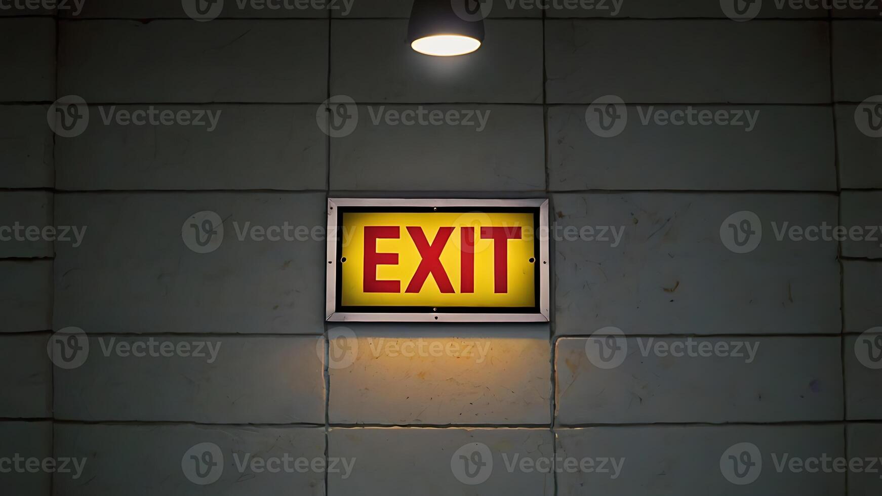 Emergency exit sign lit with red letters on yellow background for safety business purposes photo