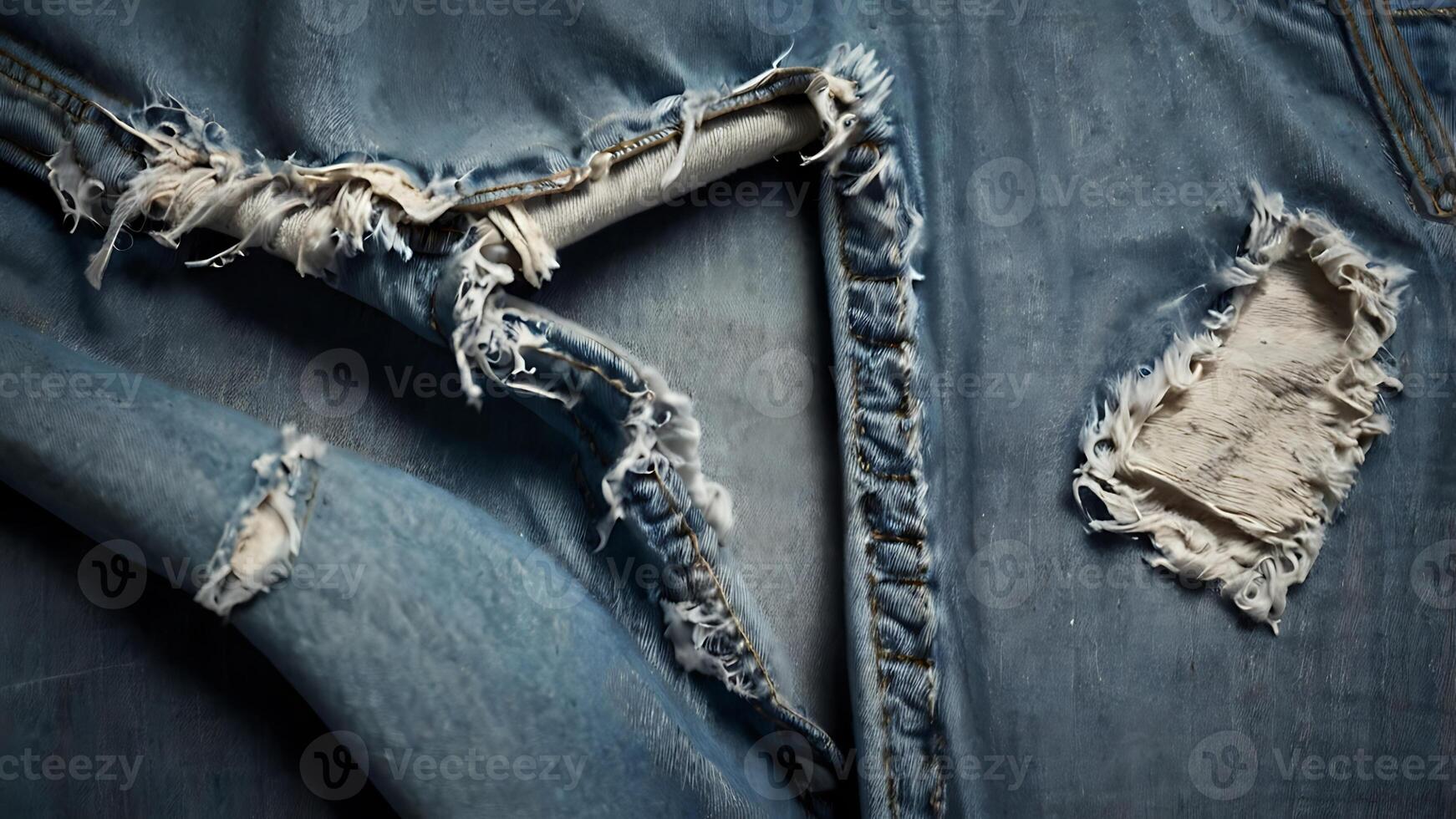 Close-up of torn denim jeans with exposed threads and frayed edges for fashion business photo