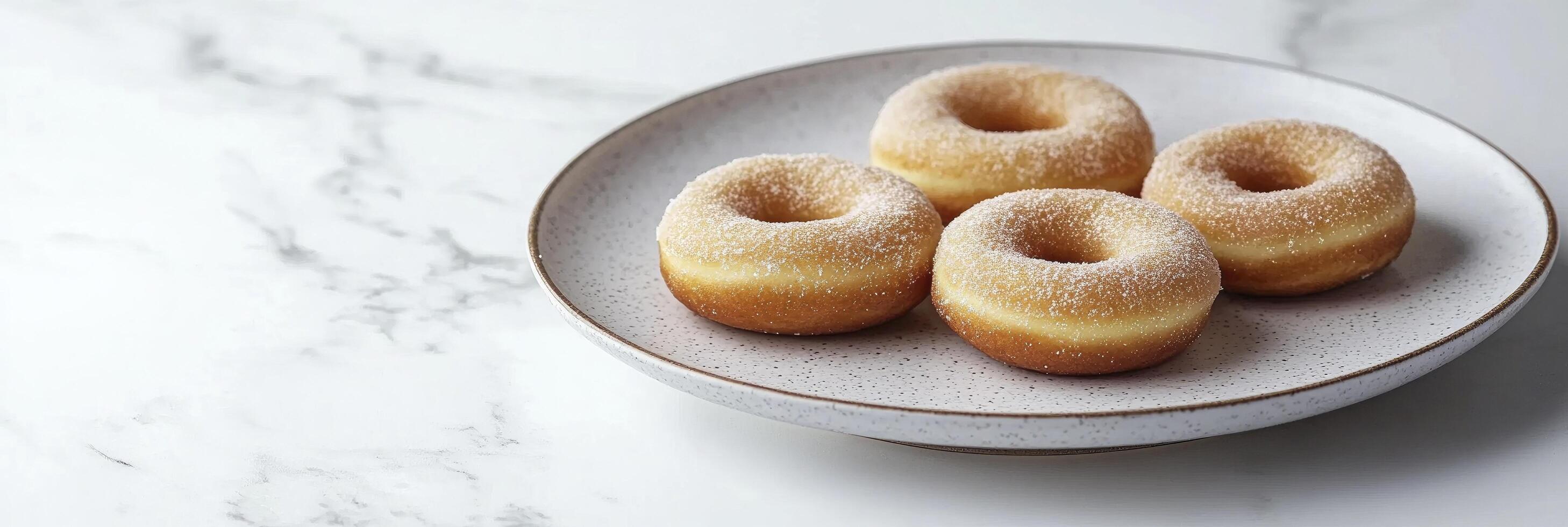 A plate with doughnuts on a white marble table photo