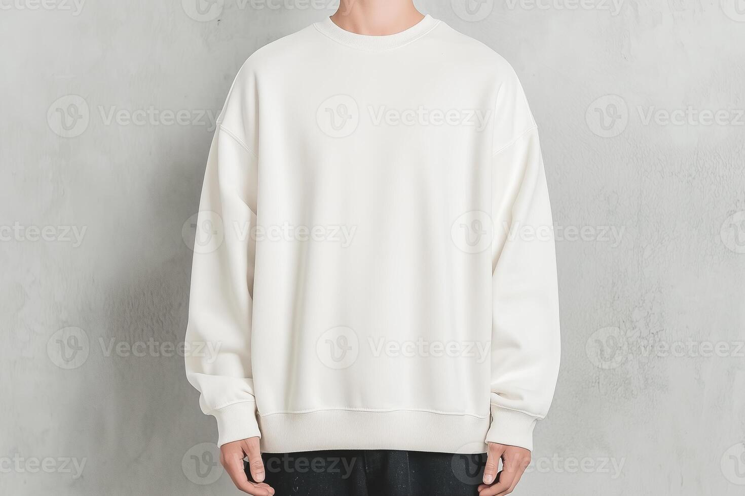 A plain white sweatshirt worn by a person, presented against a textured neutral wall. Perfect for showcasing simplicity and modern casual style photo