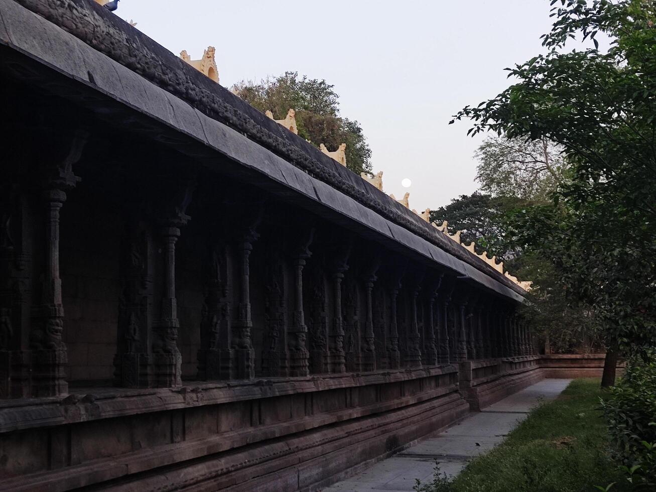 The long walkway is lined with pillars and trees photo