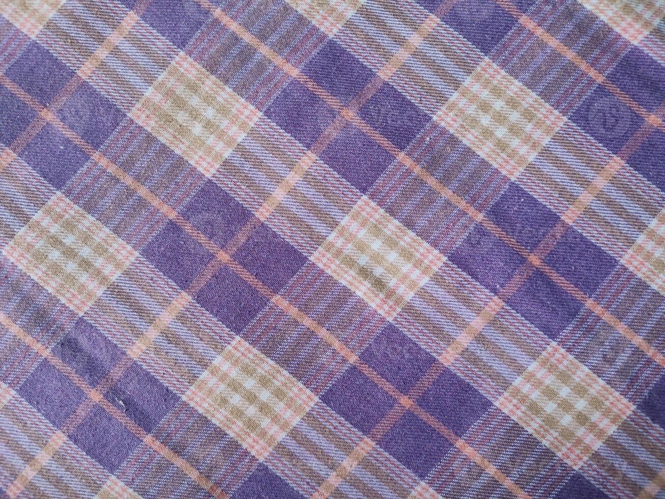 a purple and green plaid fabric with a small white square photo