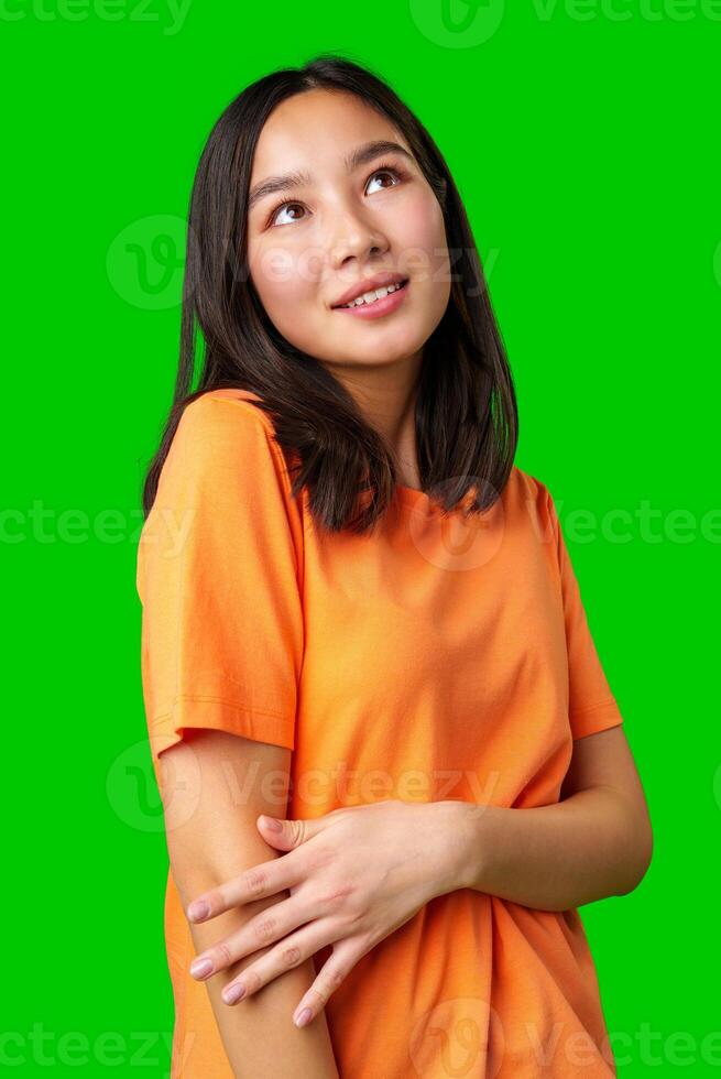Young woman with a bright smile poses against a vibrant green background, showcasing casual fashion and cheerful demeanor photo