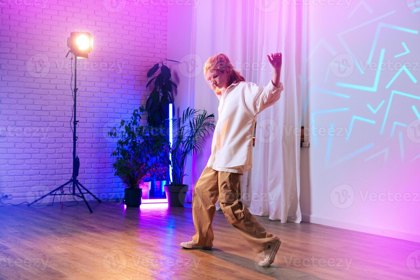 Dancer showcasing dynamic movement in colorful studio with soft lighting and modern decor photo