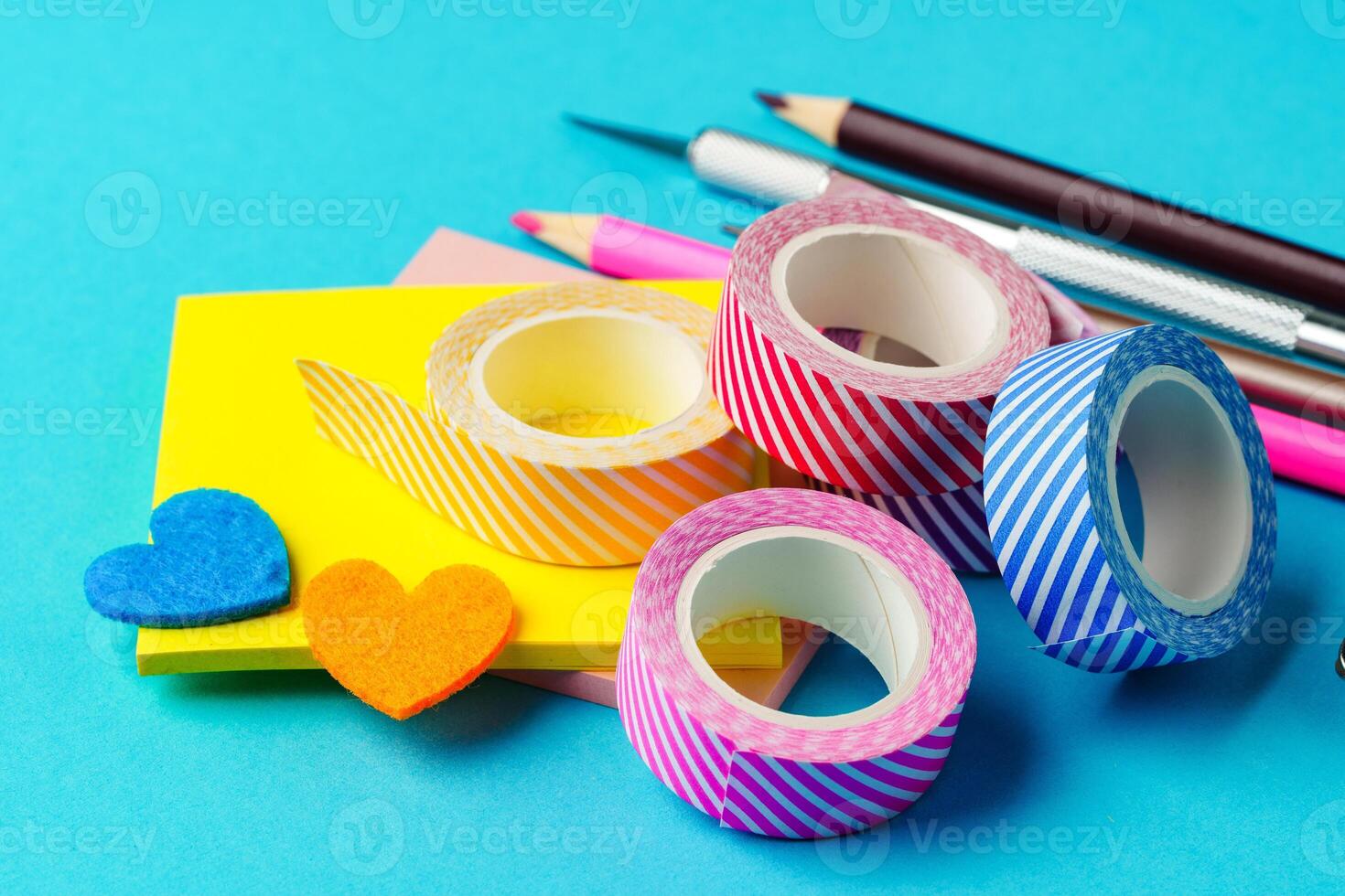 Colorful stationery items arranged on a bright blue background for crafting and organization tasks photo
