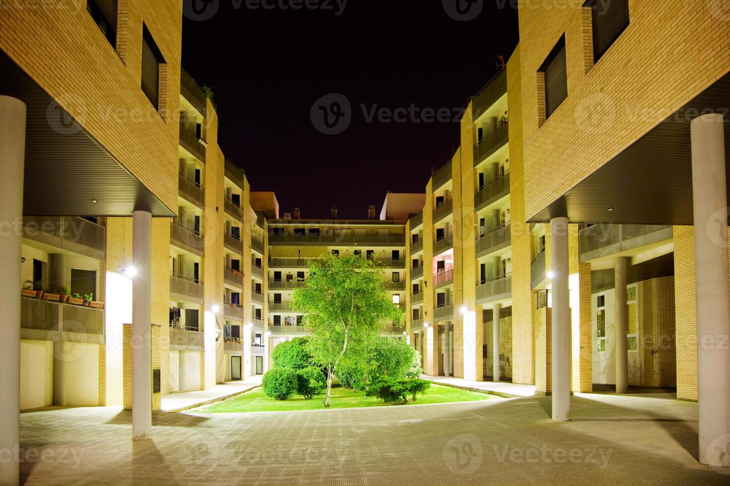 architecture Night Scene.Inside of a block of flats with garden and tree photo