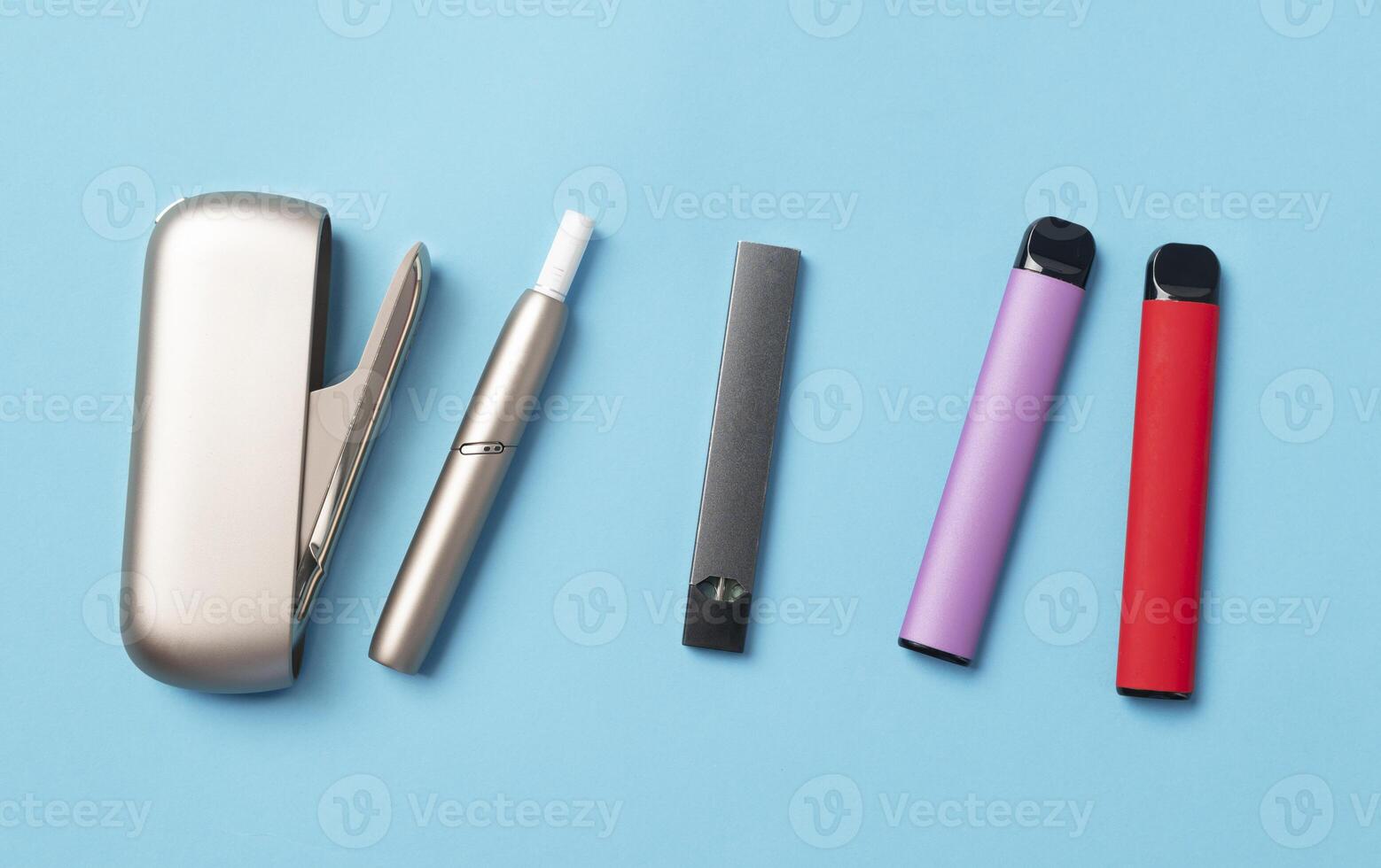 An alternative to cigarettes Different electronic cigarettes on blue background. Smoking alternative photo