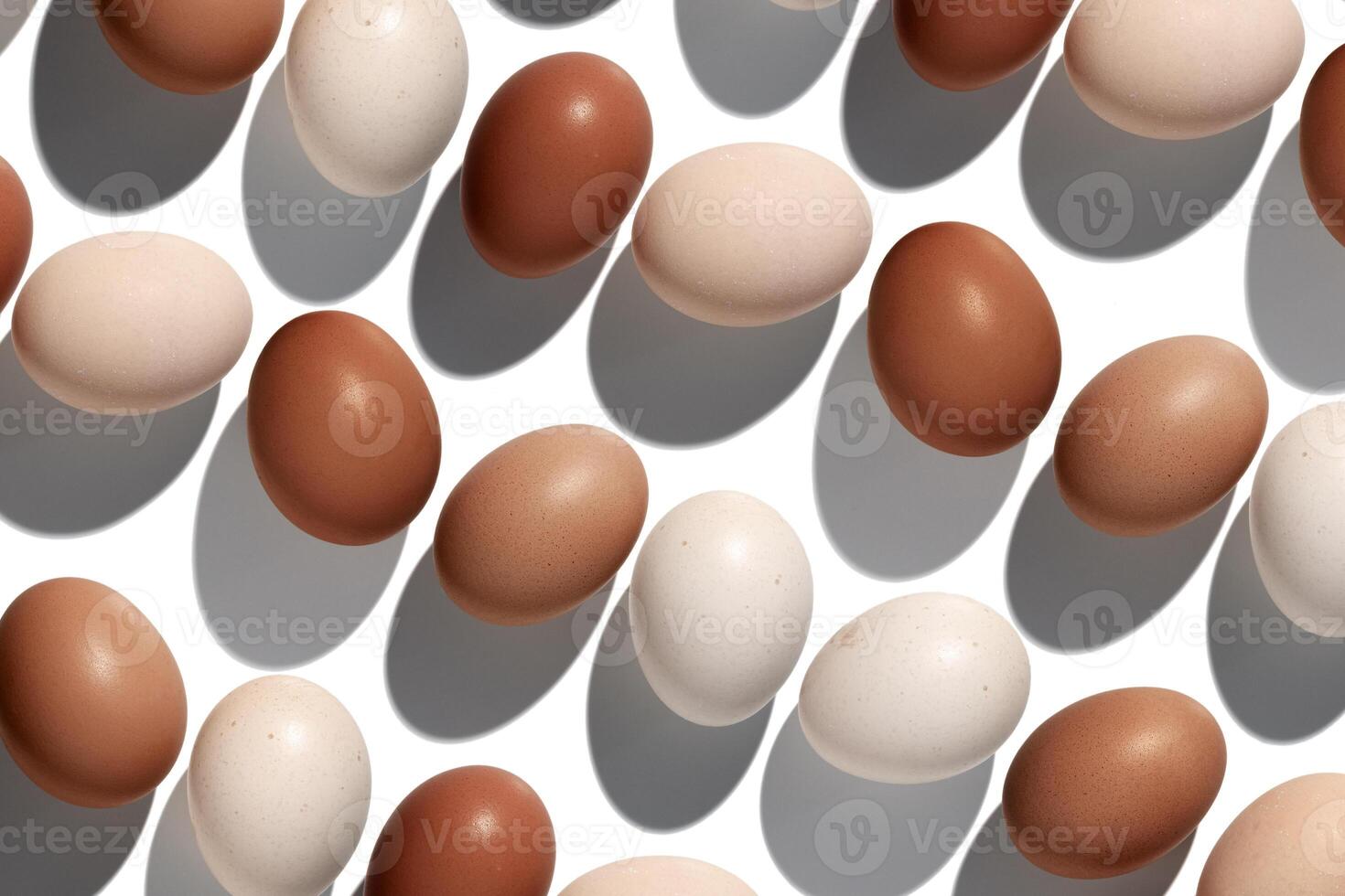 Top view Brown Eggs with shadows in white background, minimal trend food pattern from assorted natural Chicken egg with natural beige brown color eggshells, Easter food celebration concept, flatlay photo