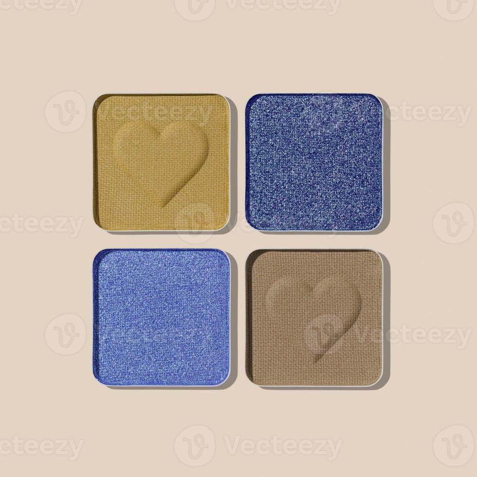 Colorful Eyeshadow Palette with Matte and Shimmer blue green yellow colored shades on beige. Set of eyeshadow refills, Top view of four Swatches Eyeshadow makeup for cosmetic, makeup, beauty concept photo