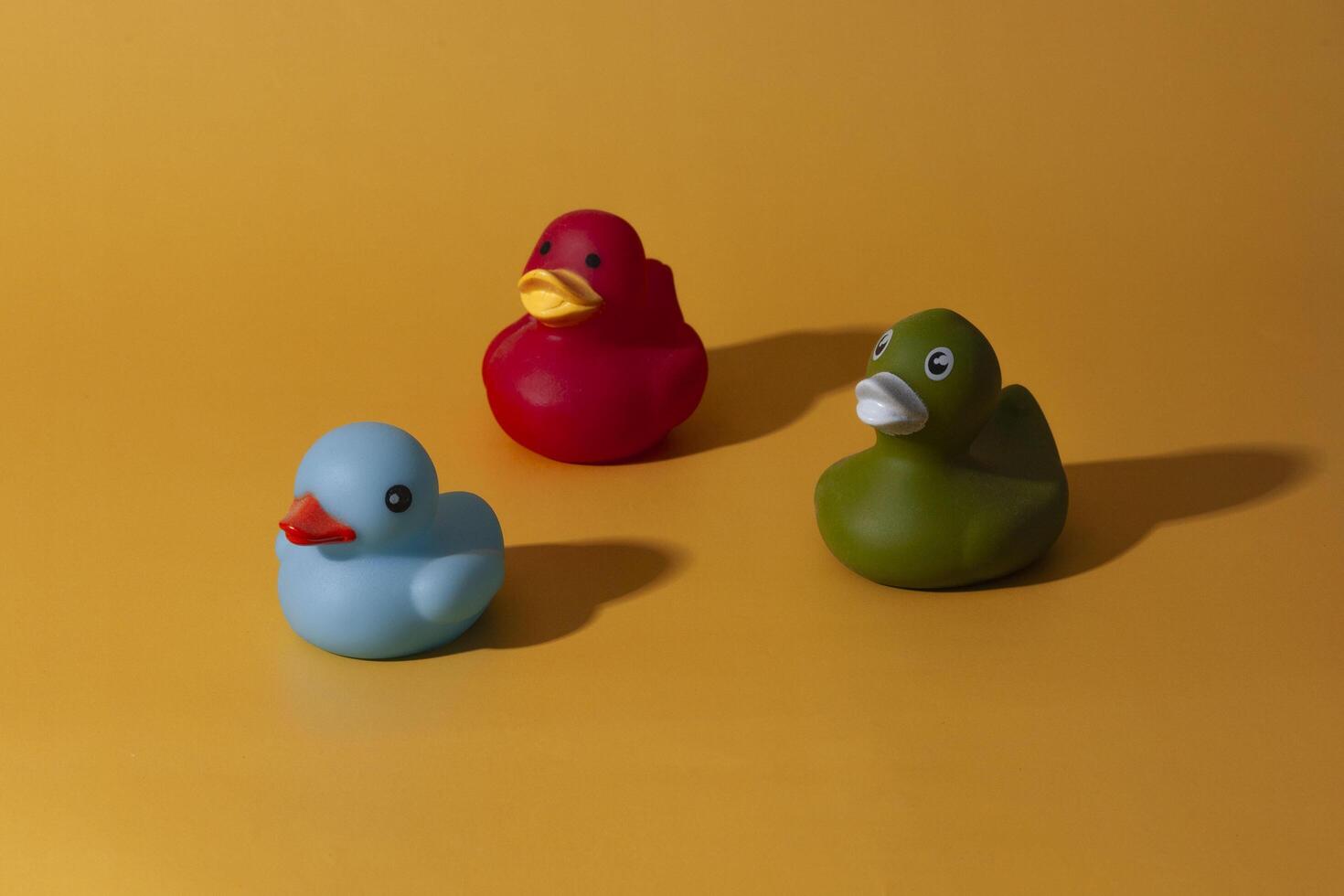 3 rubber ducks on a yellow background photo