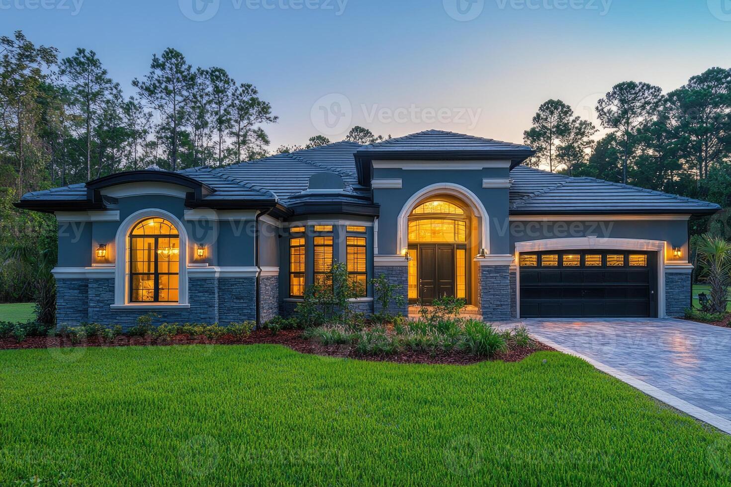 Beautiful new luxury home exterior at twilight with green lawn photo