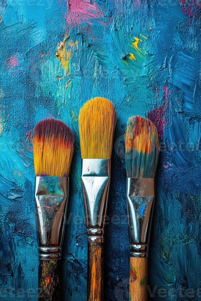 Paintbrushes resting on vibrant oil painting, embracing artistic expression photo