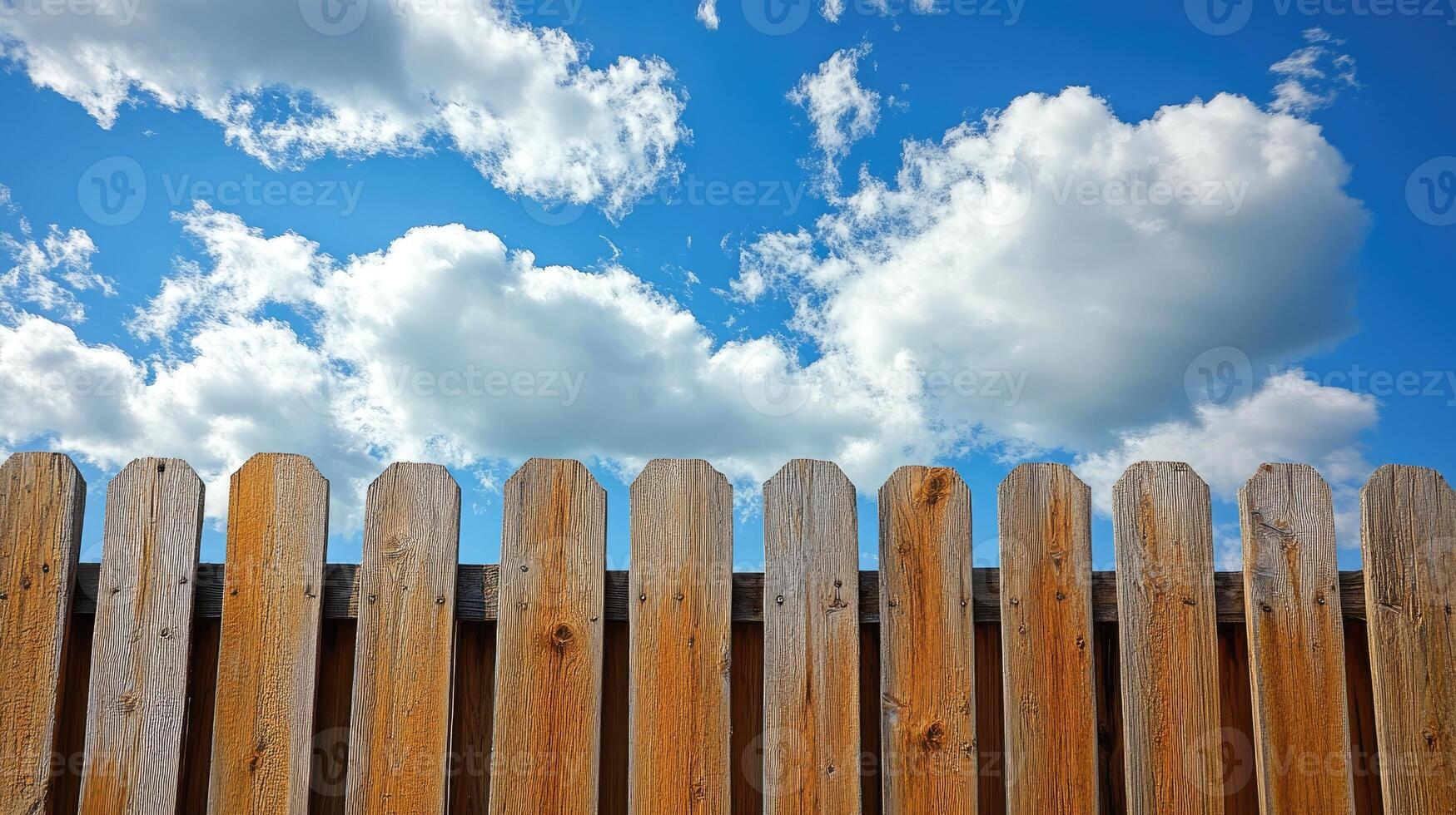 Wooden picket fence under cloudy blue sky, representing security and privacy photo