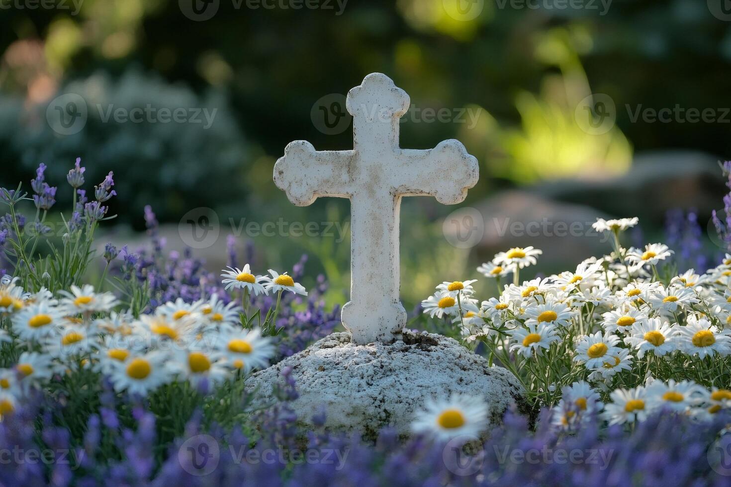 White christian cross standing on a rock surrounded by daisies and lavender flowers photo